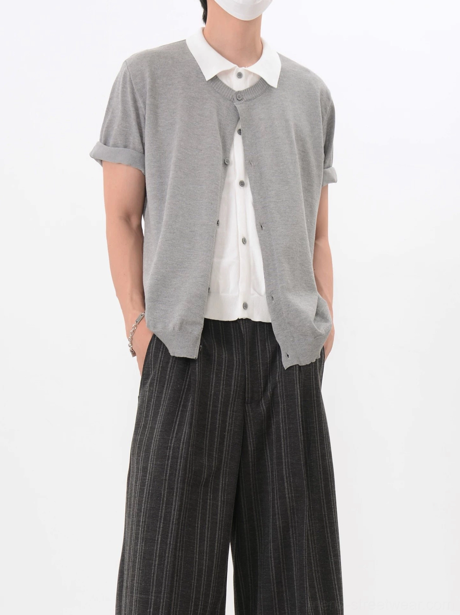 Full body look of gray layered knit cardigan shirt with white collar insert paired with striped relaxed-fit trousers