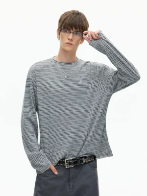 Three-quarter front view of a relaxed striped long sleeve crew neck tee with thin grey black stripes, drop shoulders, and casual streetwear styling