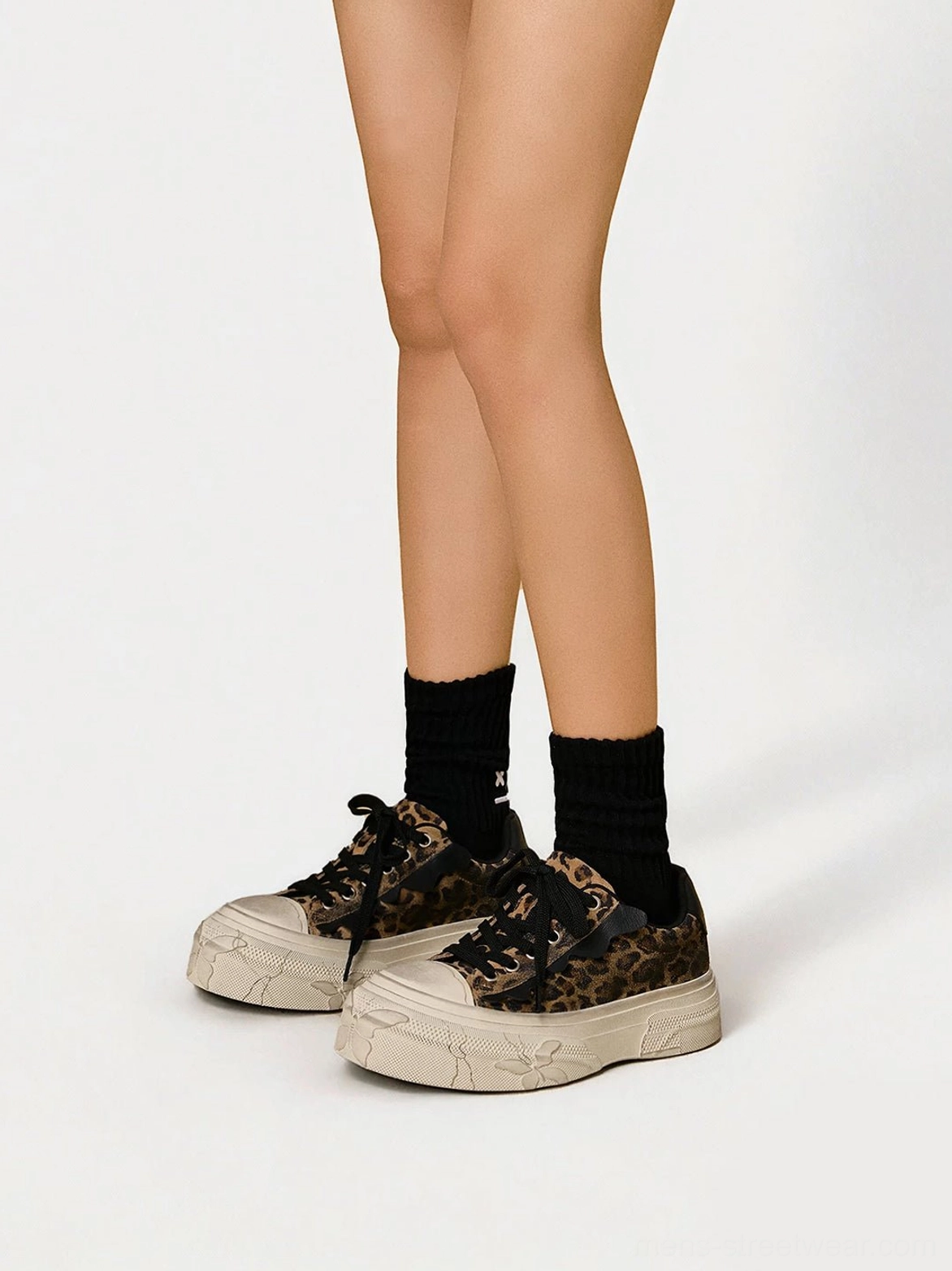 Front view of matching leopard distressed canvas platform sneakers with weathered soles and embossed toe cap details