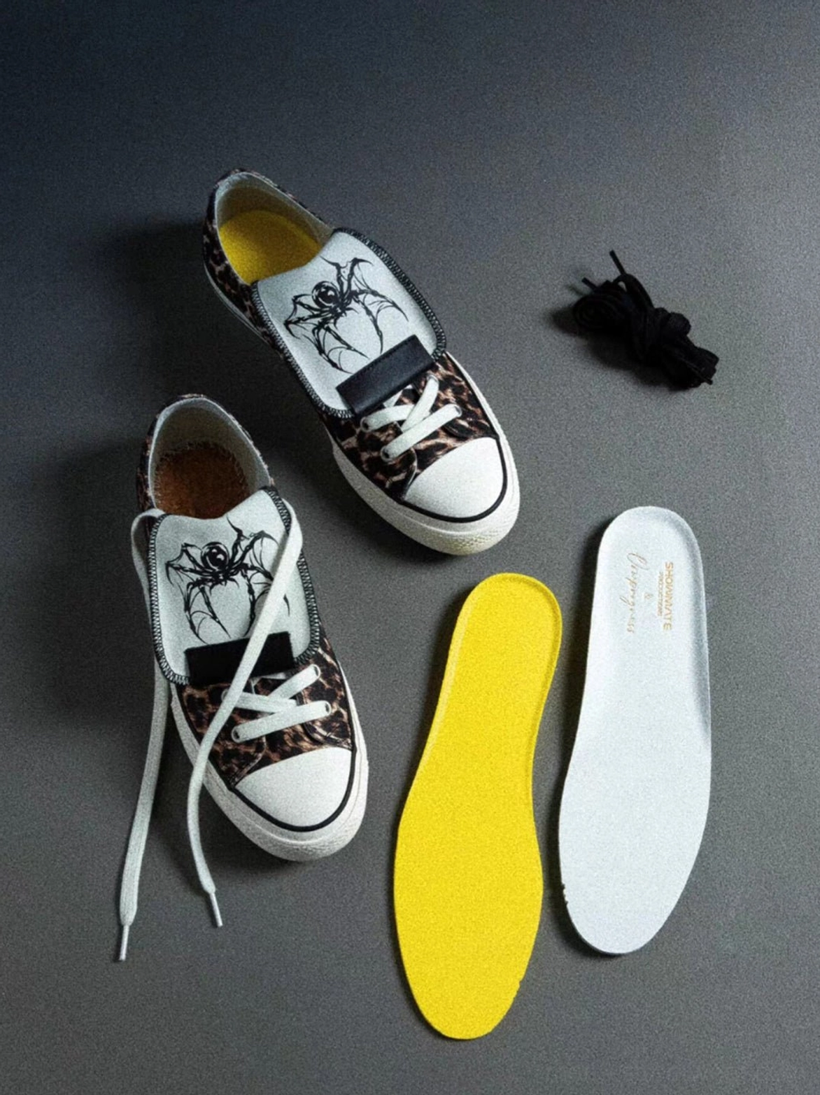 Leopard print canvas sneaker set with yellow and white replacement insoles, extra laces, and white spider embroidery on the tongue