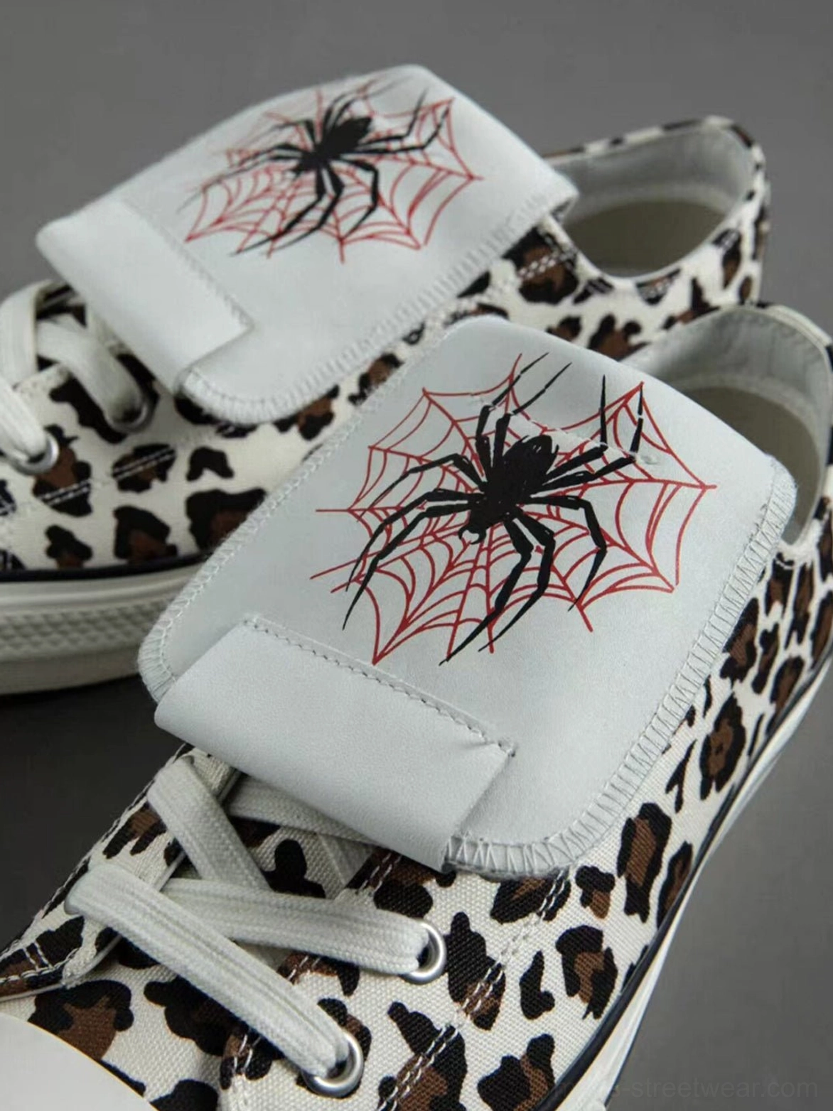 Leopard print low-top canvas sneakers featuring a detachable embroidered spider tongue and punk-inspired streetwear construction