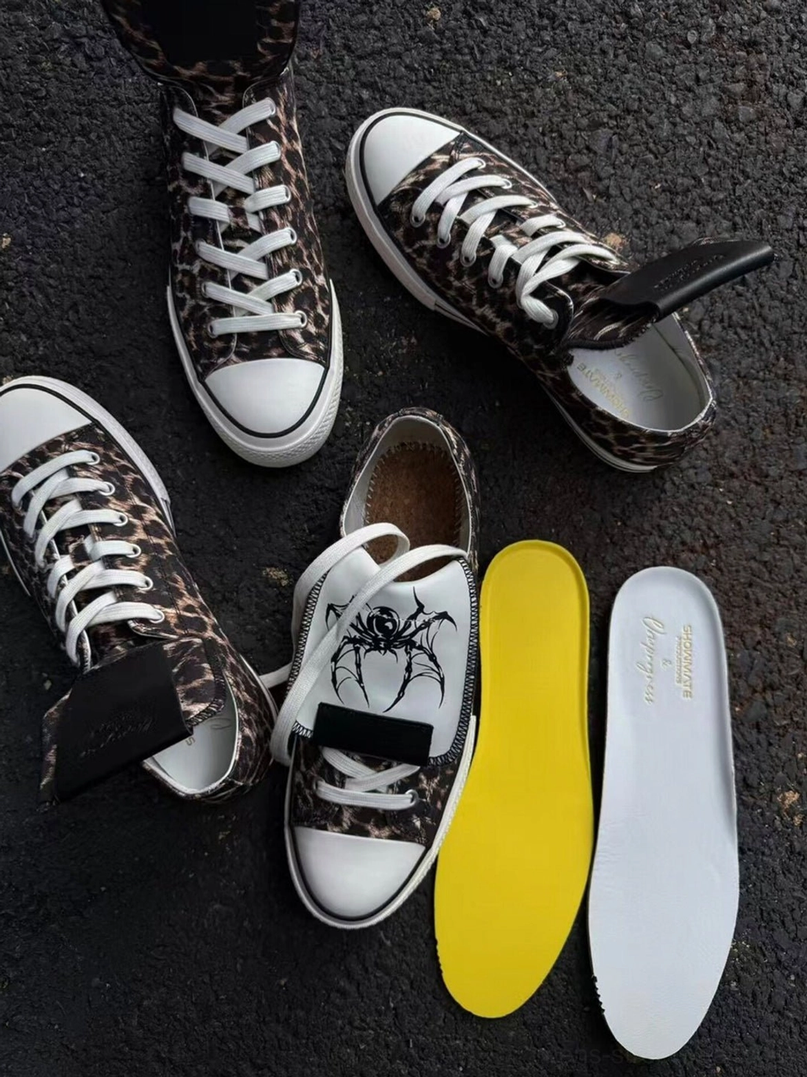 Multiple leopard spider-tongue canvas sneakers displayed with replacement insoles and extra shoelaces for customizable streetwear styling