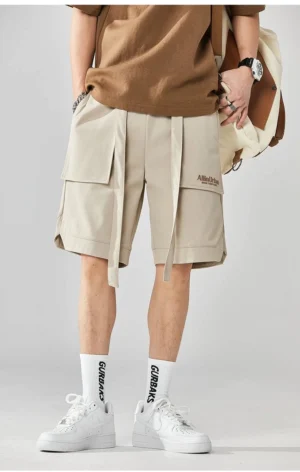 Back view of light beige men's cargo shorts featuring a relaxed silhouette back patch pocket and adjustable drawstring streetwear styling