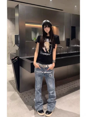 Female model styling light blue faded flare jeans with printed front emblem silver belt and wide legs in modern Korean streetwear fashion