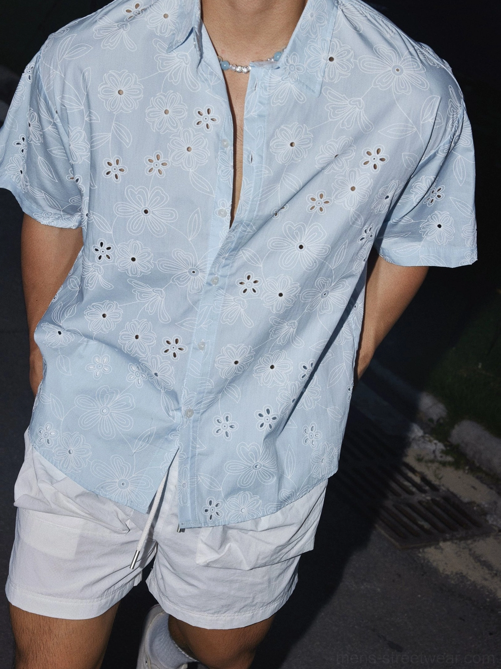 Close-up view of light blue floral eyelet embroidery and breathable cotton blend texture on a short sleeve shirt
