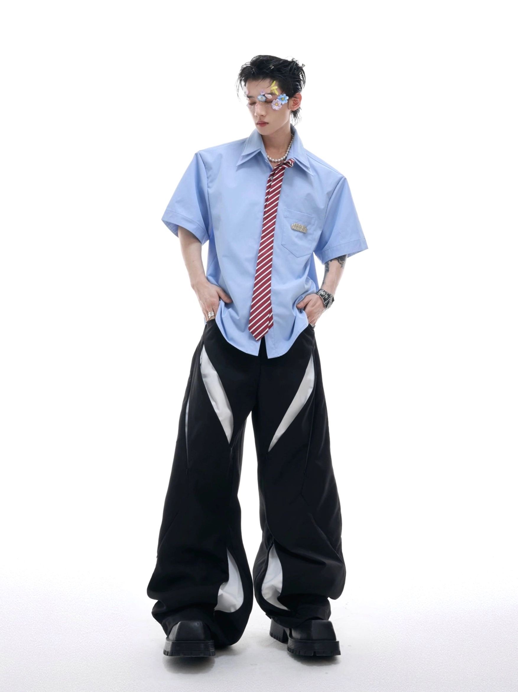 Light blue oversized short sleeve shirt with orange red striped necktie and black striped wide leg pants