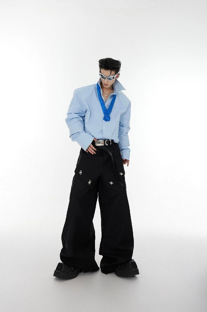 Light blue oversized shoulder pad tie-neck shirt full front view styled with black wide-leg cargo pants and silver sunglasses