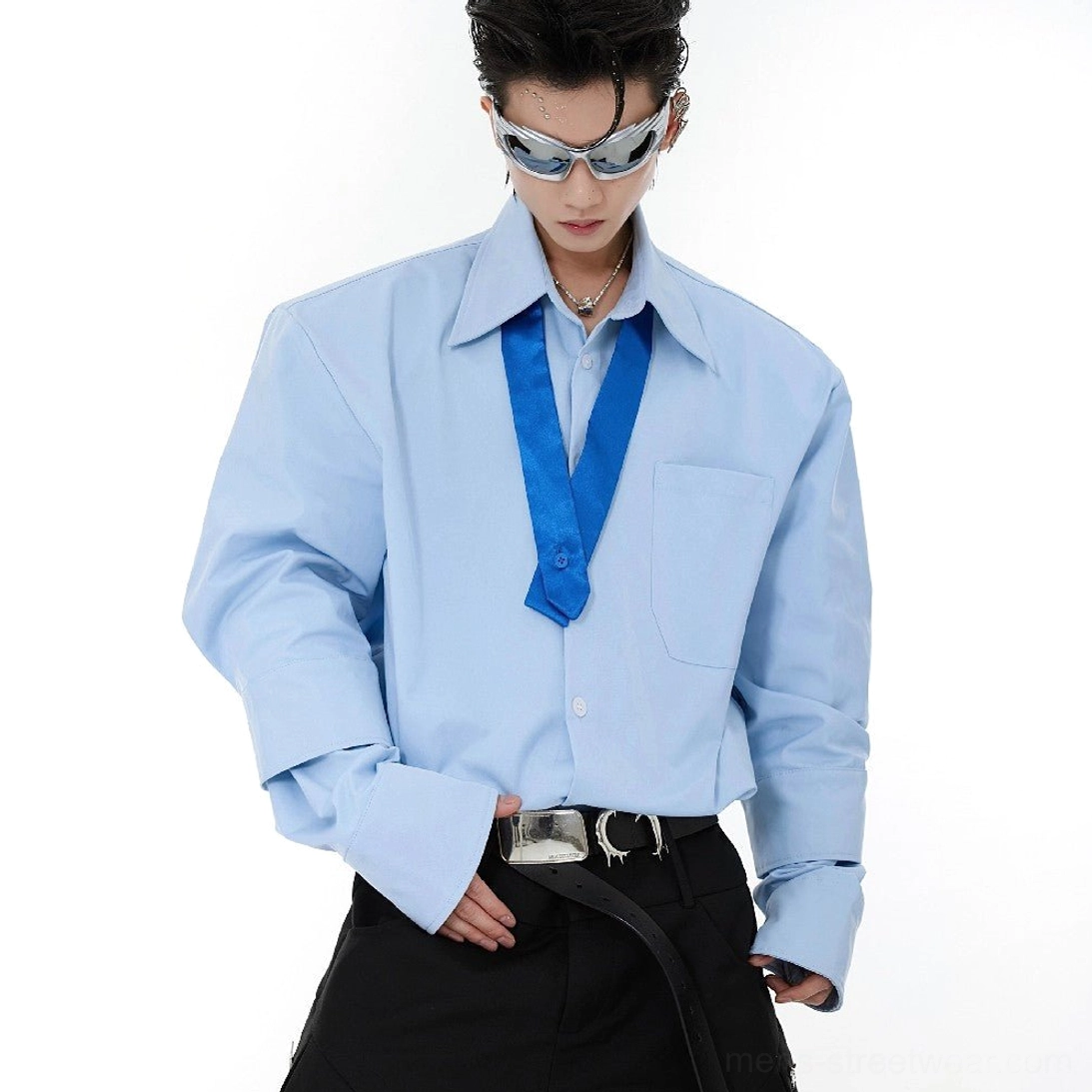 Light blue oversized shoulder pad tie-neck streetwear shirt front view with tonal blue tie and black cargo pants