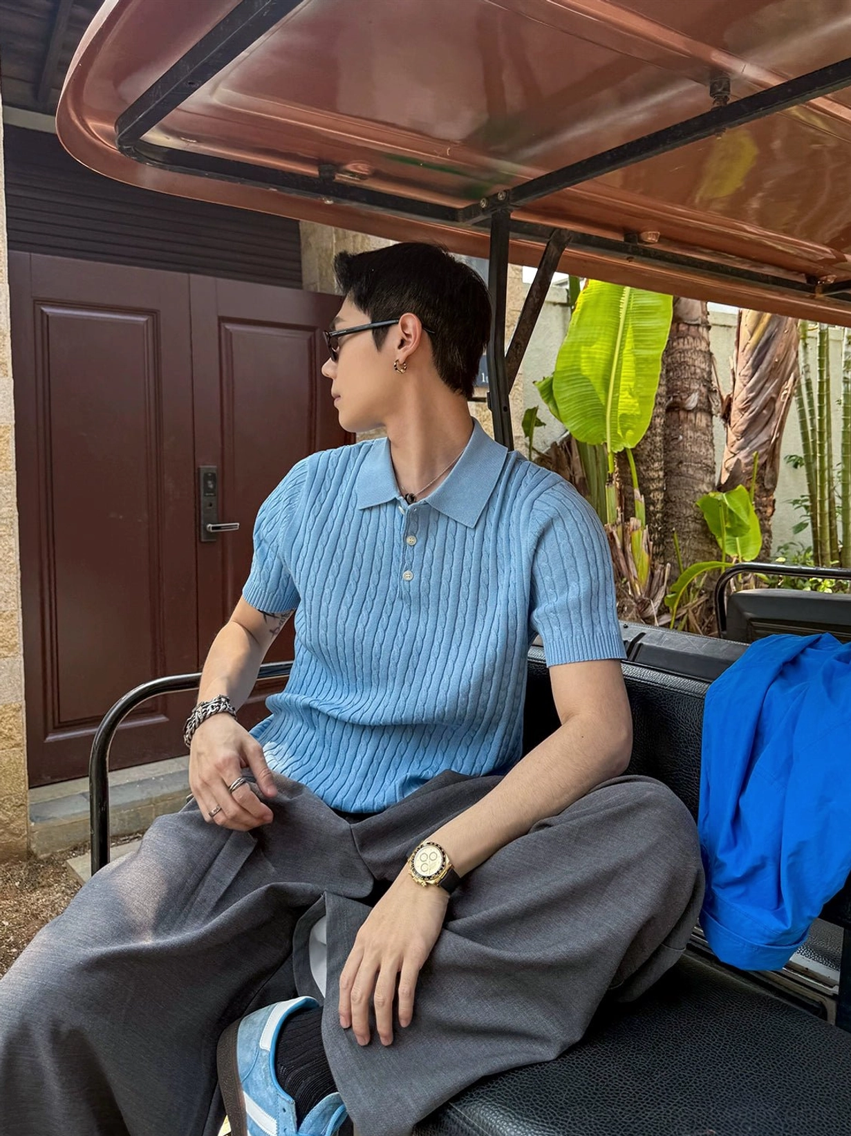 Light blue short sleeve textured knit polo shirt styled with accessories in a modern outdoor Korean inspired summer outfit