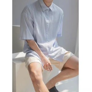 Front view of light blue men's textured stripe button up shirt with vertical textured stripes and boxy fit