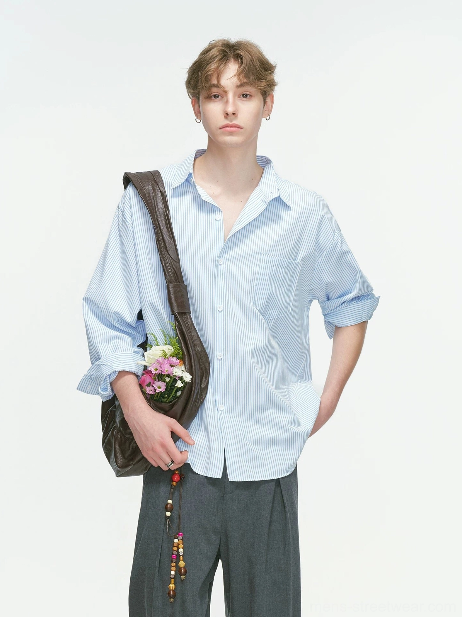 Light blue vertical stripe Korean streetwear overshirt shown in a relaxed three-quarter view with grey wide-leg trousers and a brown leather shoulder bag