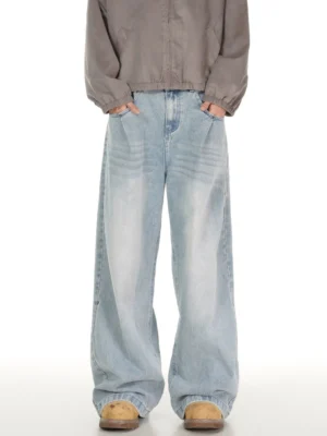 Light blue vintage wash wide leg jeans with front pleats styled with a grey zip-up jacket and tan boots