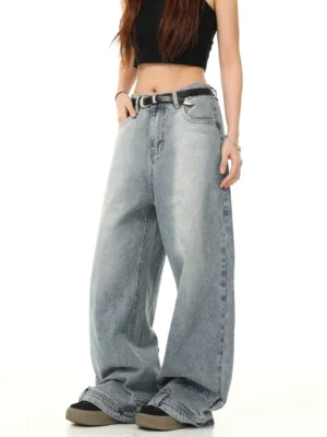 Three-quarter view of light blue vintage Y2K wide-leg baggy jeans styled with a black cropped top belt and casual shoes