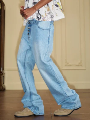 Light blue washed asymmetric waist wide-leg stacked denim jeans worn by male model in side walking view