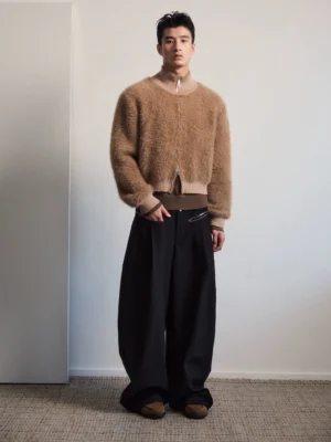 Full-body styling of a light brown plush bomber jacket with black wide-leg pants and brown suede loafers