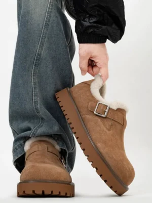 Light brown suede shearling buckle platform clog worn with blue jeans and a black coat, showing the chunky lug sole and cozy winter streetwear design