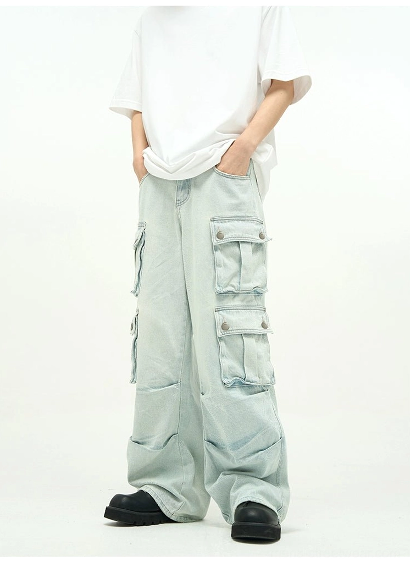 Close front view of light faded baggy cargo denim showing oversized side flap pockets, relaxed wide-leg shape, and utility streetwear styling