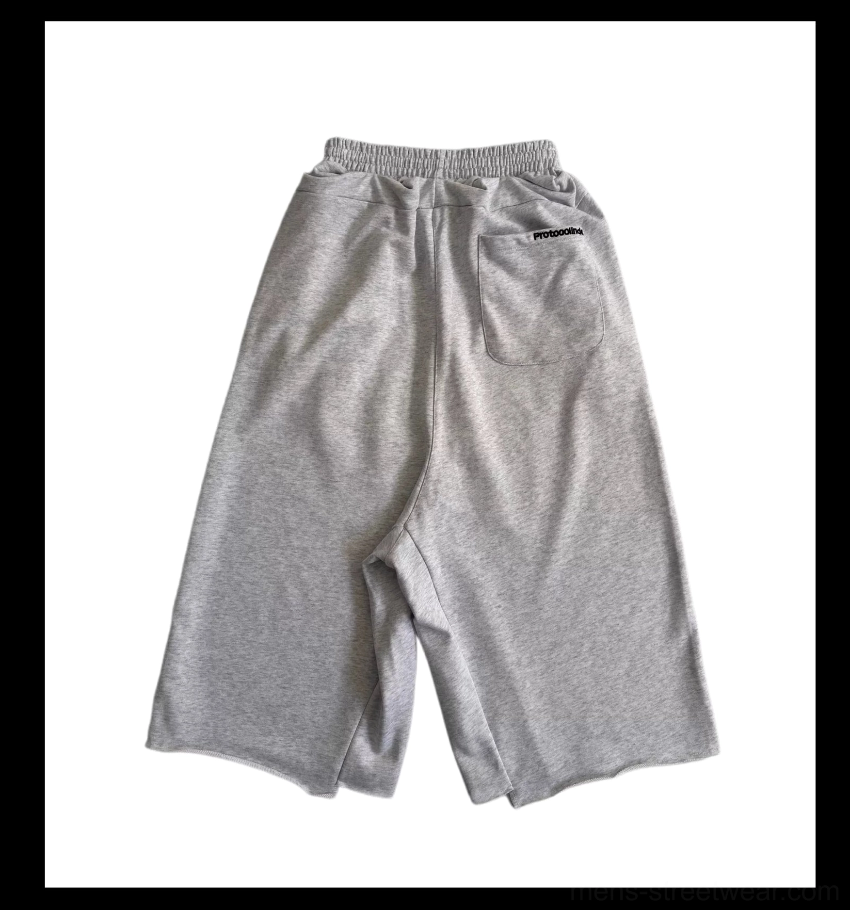 Flat lay rear view of light gray 7/8 cropped court shorts with elasticated waistband, wide legs, and small back pocket