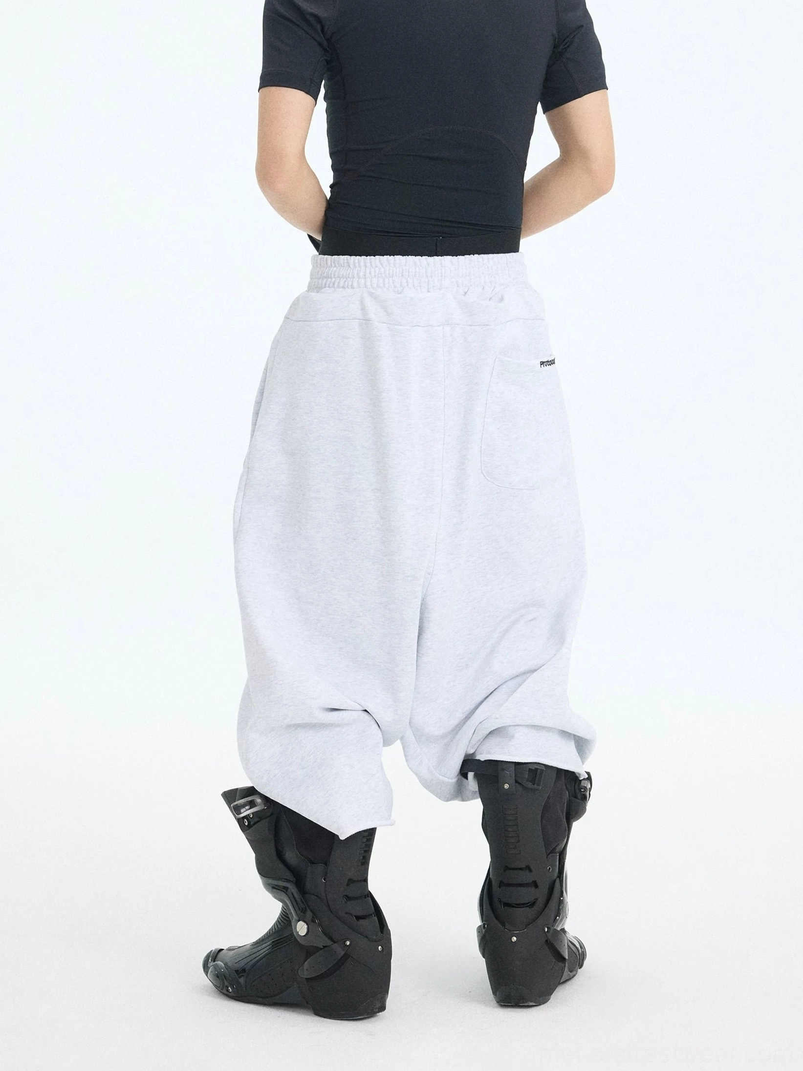 Rear three-quarter view of light gray cropped court shorts showing the elasticated waistband, wide-leg shape, and clean back pocket detail