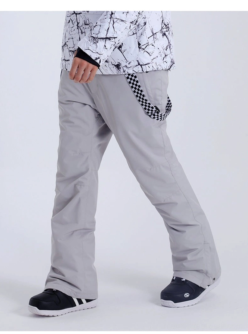 Light gray detachable strap snow pants shown in a side wearing view with a black and white winter outfit