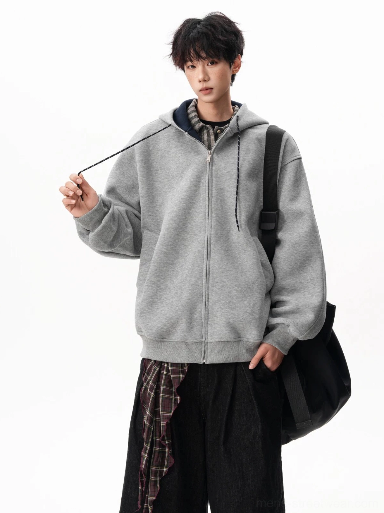 Three-quarter view of a light gray fleece zip-up hoodie with adjustable drawstrings, hand pockets, and relaxed fit