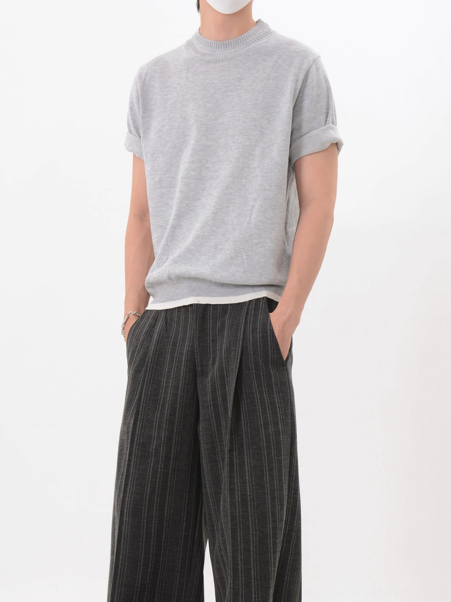Light gray layered-look knit short sleeve T-shirt with rolled sleeves and contrast hem styled with solid dark wide leg pants