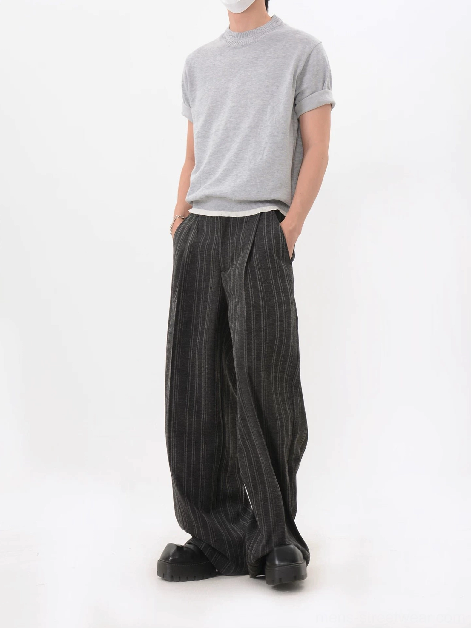Light gray textured knit T-shirt with layered white underlayer detail and rolled sleeves paired with pleated striped wide leg pants