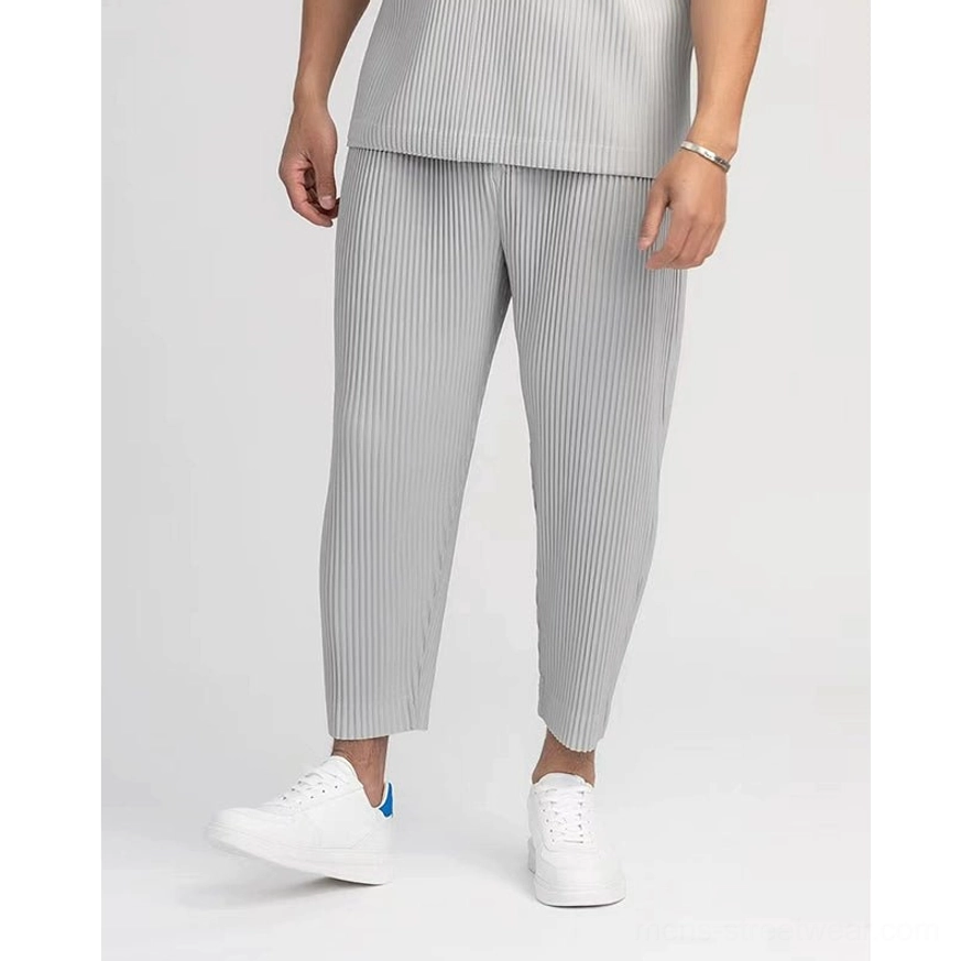 Light gray men's pleated cropped pants styled with a matching cropped top and clean white sneakers in minimalist Korean fashion