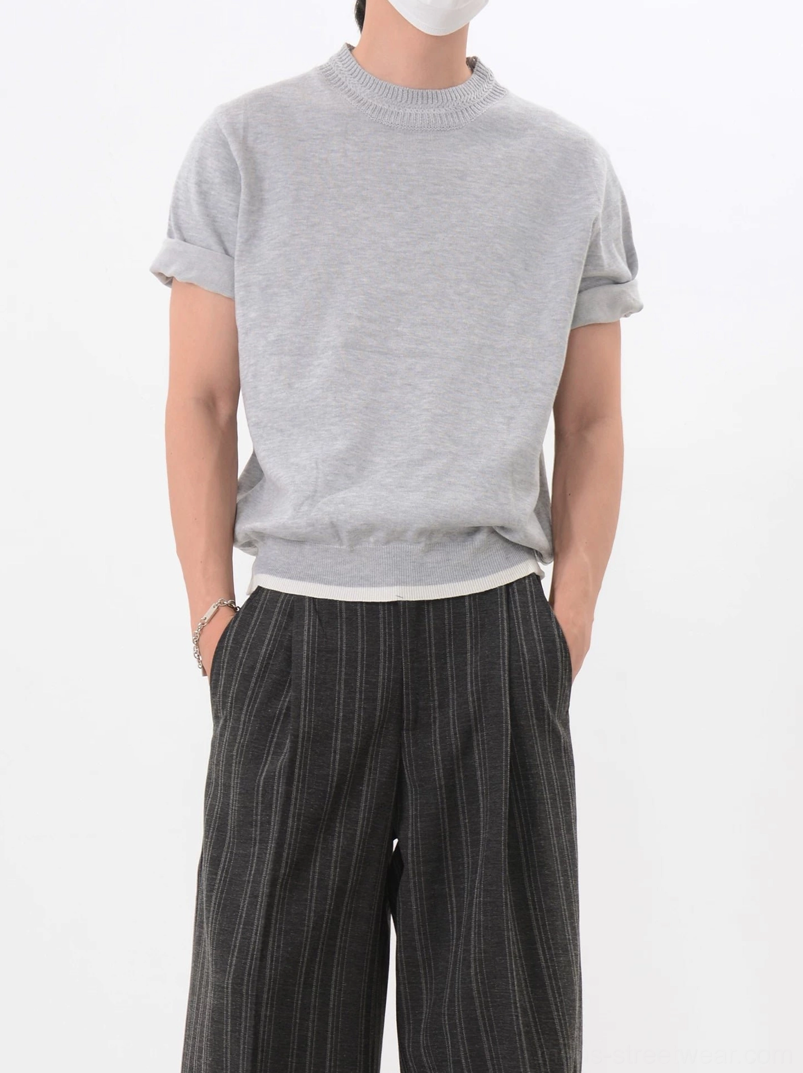 Light gray mock layered knit short sleeve T-shirt with rolled cuffs and white contrast hem styled with vertical striped wide leg trousers