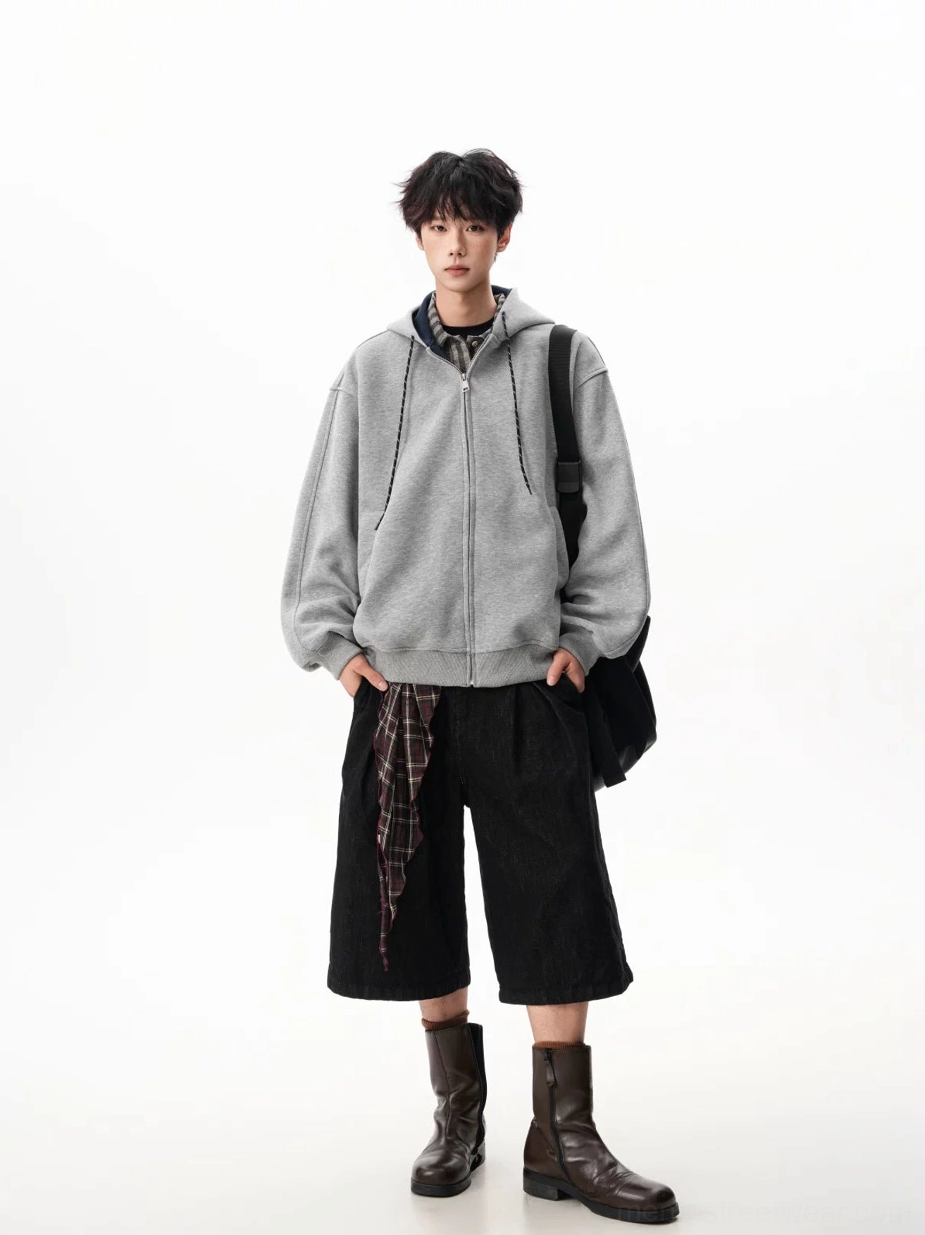 Light gray oversized fleece hoodie with front pockets styled with knee-length black pants and boots