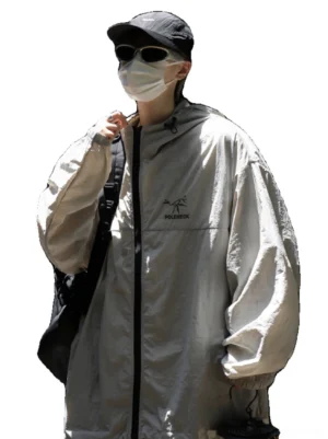Light gray oversized hooded outdoor sun protection jacket shown from the front with full zipper, chest embroidery, elastic cuffs, crossbody backpack, and relaxed streetwear fit
