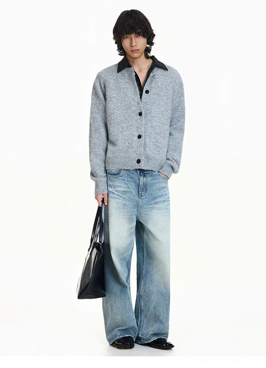 Light gray oversized polo cardigan with full button front styled with wide-leg blue jeans black leather tote and loafers