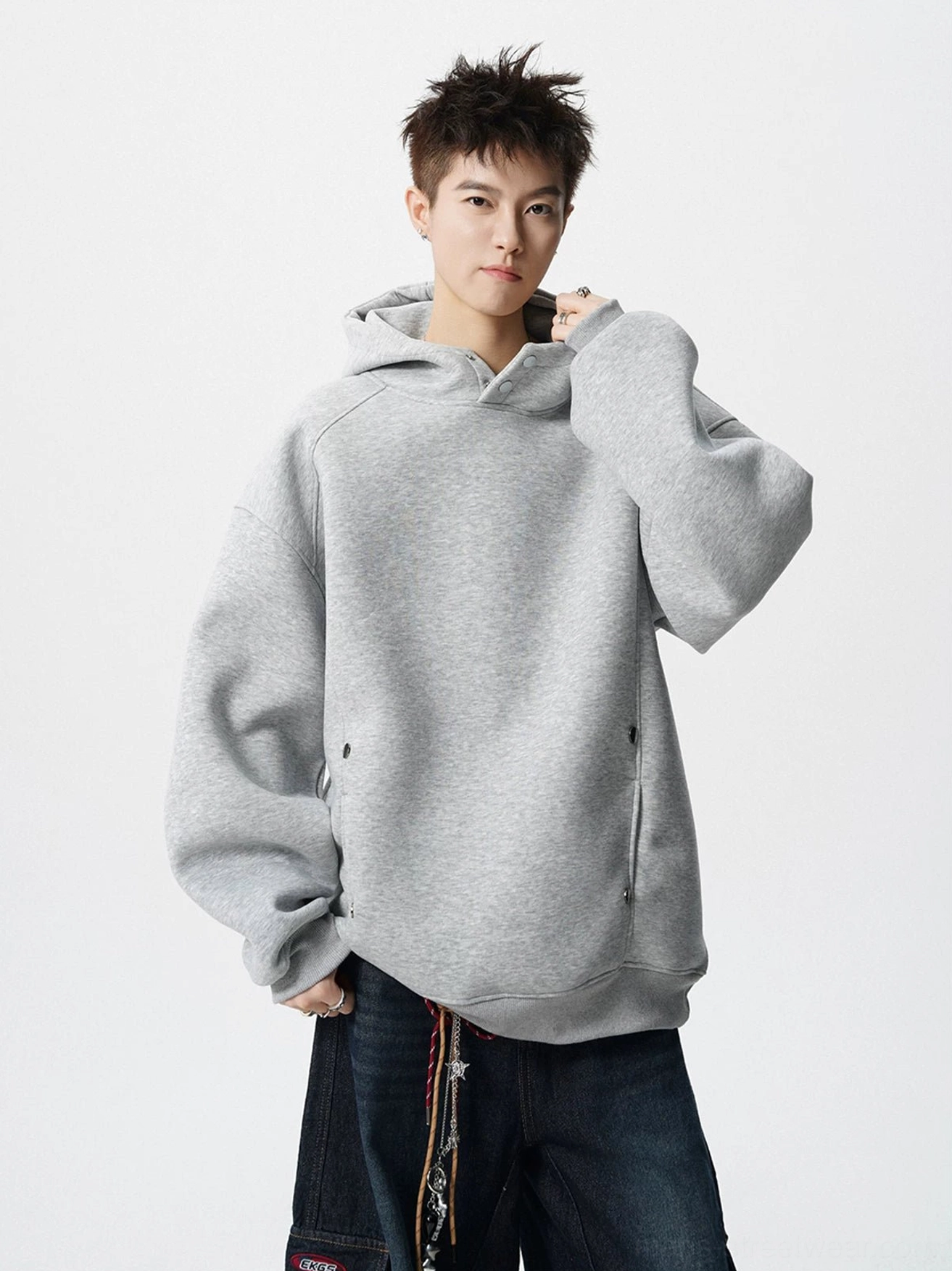 Light gray oversized fleece hoodie with snap neck collar and side pockets styled with dark wide leg jeans