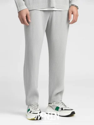 Light gray pleated straight-leg trousers shown in a lower-body front view with fine vertical pleats and chunky color-block sneakers