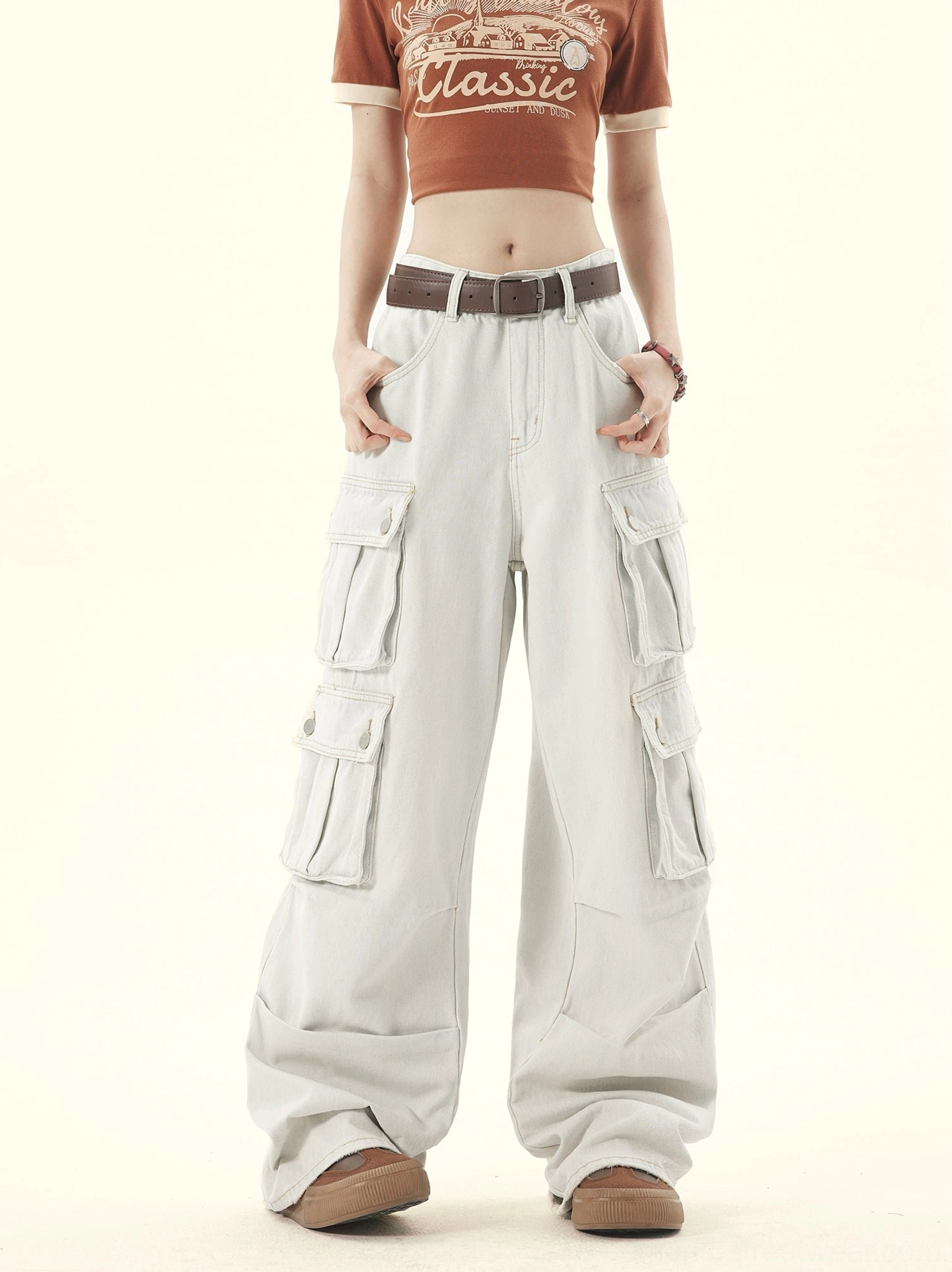 Light gray washed denim cargo pants shown from the front with layered thigh pockets and wide-leg silhouette