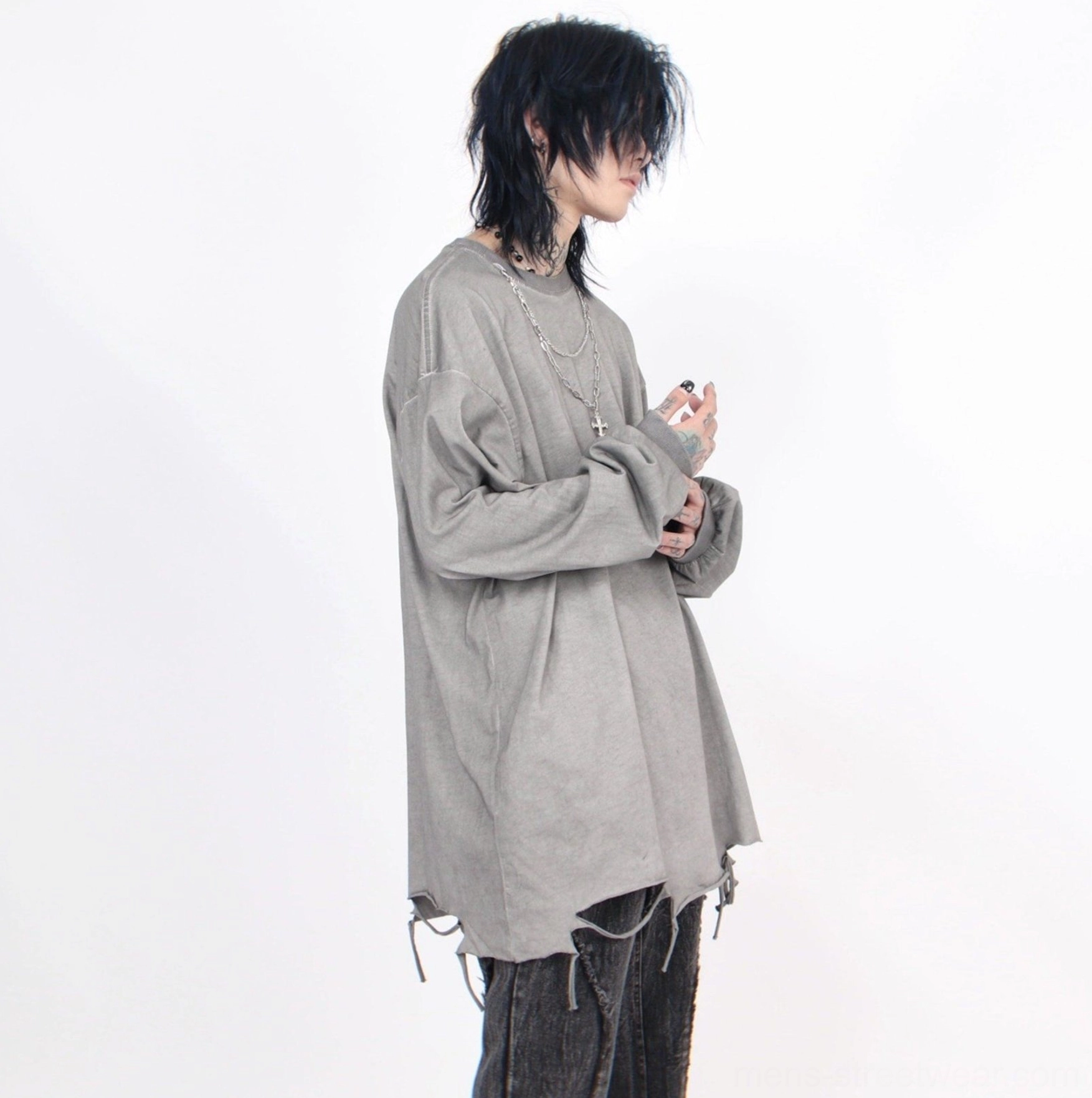 Side view of light gray washed distressed oversized long-sleeve tee with loose sleeves and cross pendant