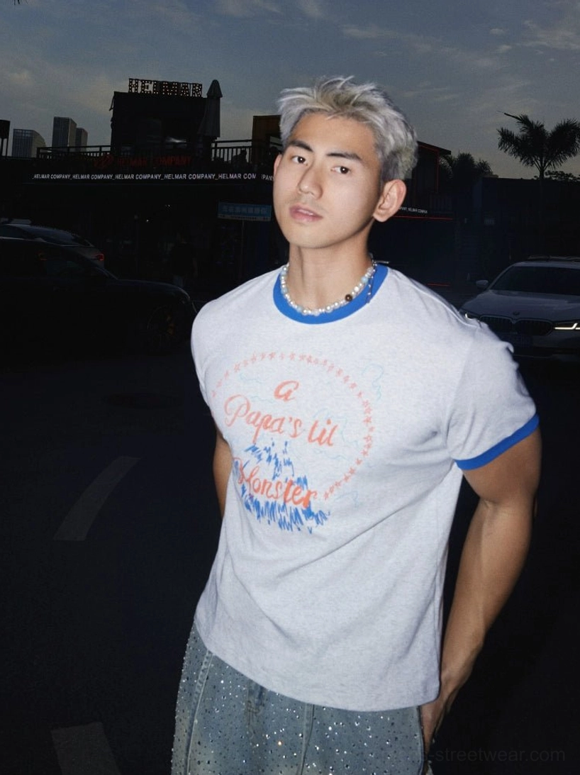 Three-quarter view of light grey cotton blend graphic ringer T-shirt with blue trim, front slogan print, pearl necklace, and Korean streetwear styling
