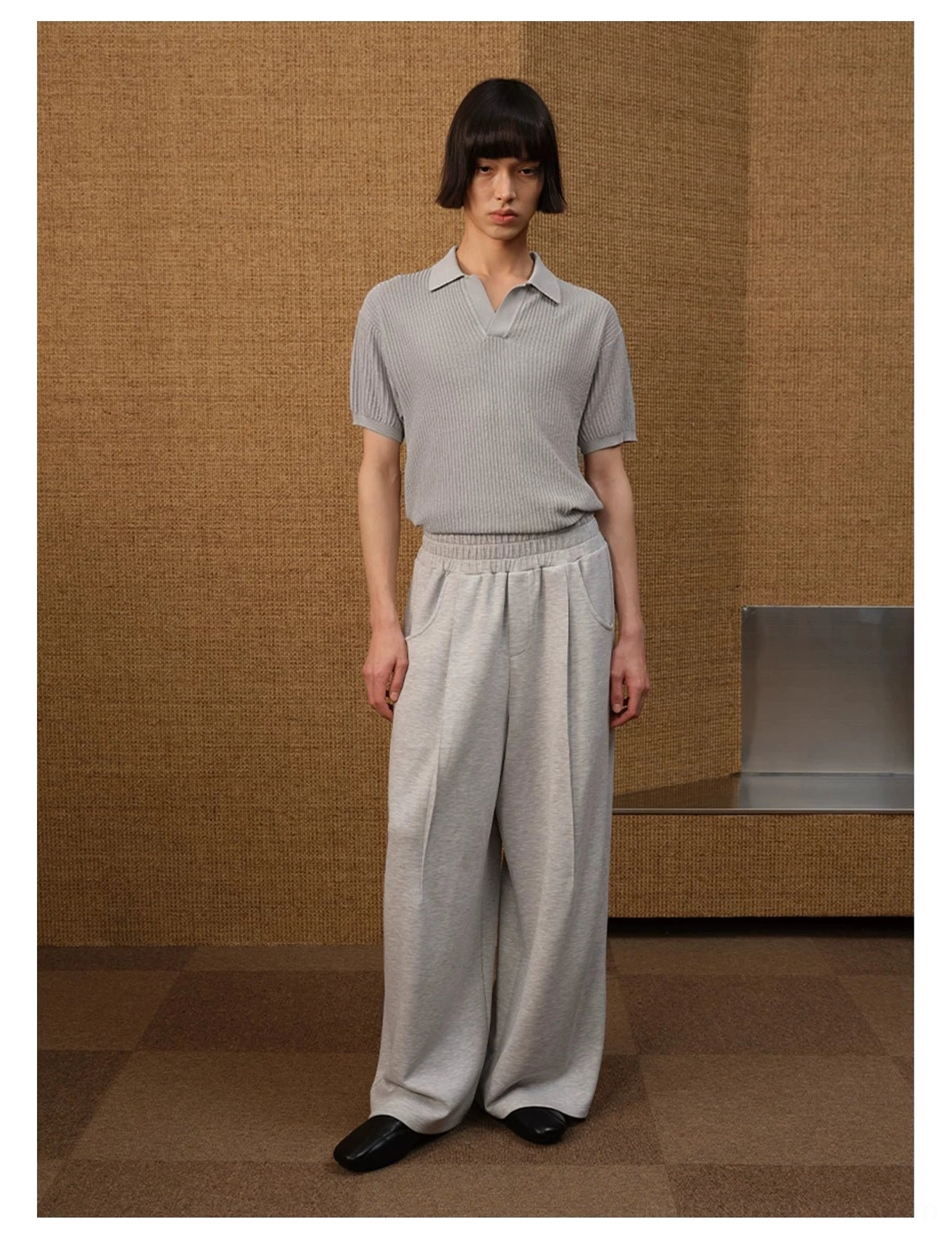 Light grey textured knit open-collar polo shirt styled with matching wide-leg trousers and black leather shoes