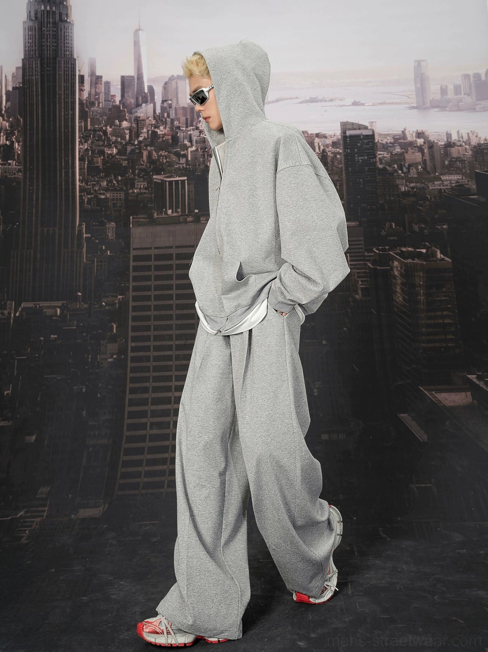Side three-quarter view of relaxed light grey wide-leg sweatpants with hidden pockets and oversized hoodie layering