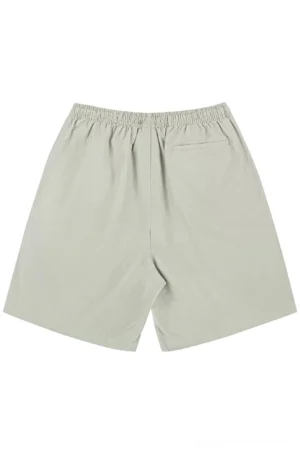Back flat lay of light khaki grey cotton beach shorts showing elastic waistband, relaxed silhouette, and rear patch pocket