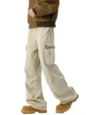 Side view of light khaki wide-leg cargo pants in washed cotton with thigh flap pockets, styled with a brown bomber jacket and tan platform boots