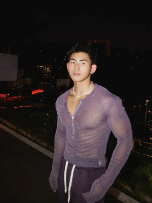 Full-length front view of a male model wearing a light purple sheer sparkly Henley long sleeve top with drawstring sweatpants
