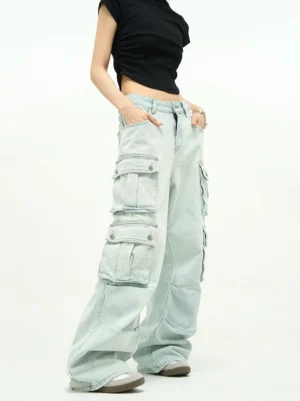 Light wash baggy cargo jeans shown from a front three-quarter view with high waist, extra-wide legs, oversized flap pockets, and faded blue denim