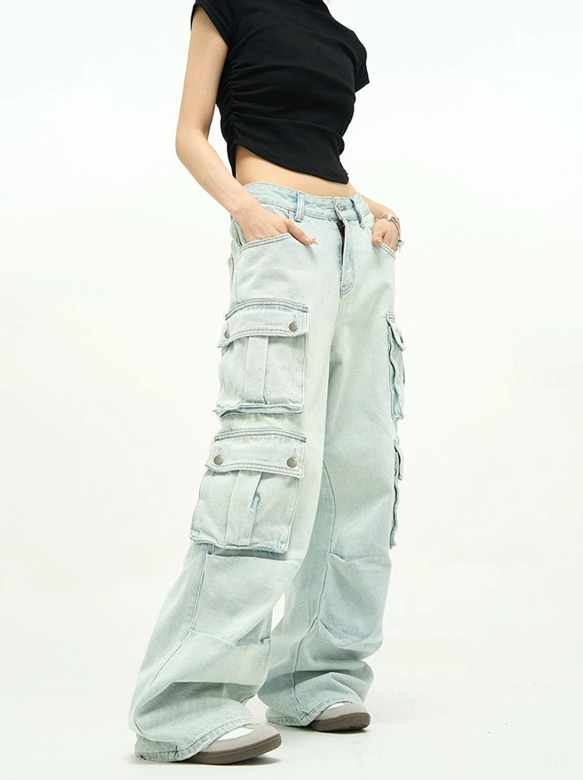 Light wash baggy cargo jeans shown from a front three-quarter view with high waist, extra-wide legs, oversized flap pockets, and faded blue denim