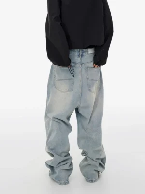 Rear view of oversized light wash baggy jeans showing classic double back pockets, wide-leg denim construction, and stacked streetwear hems