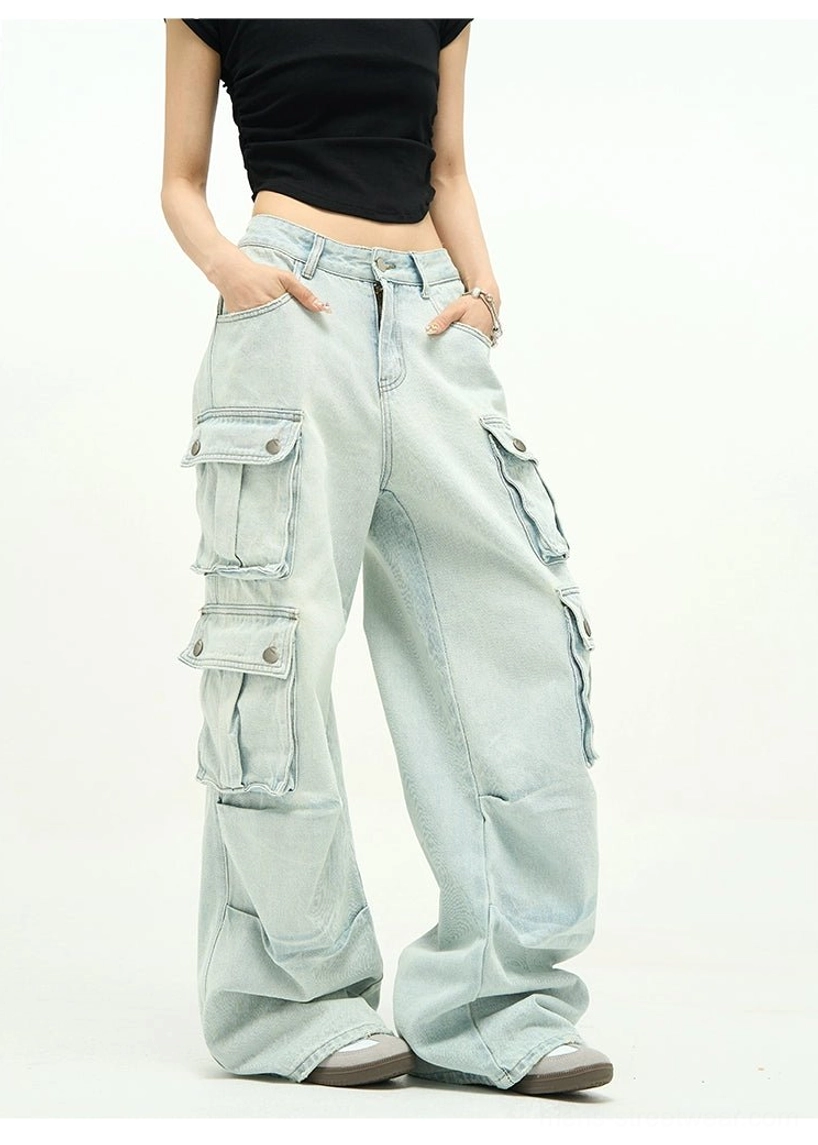 Front three-quarter detail of light wash cargo jeans with high-rise waist, zipper fly, thigh flap pockets, and faded Korean streetwear denim