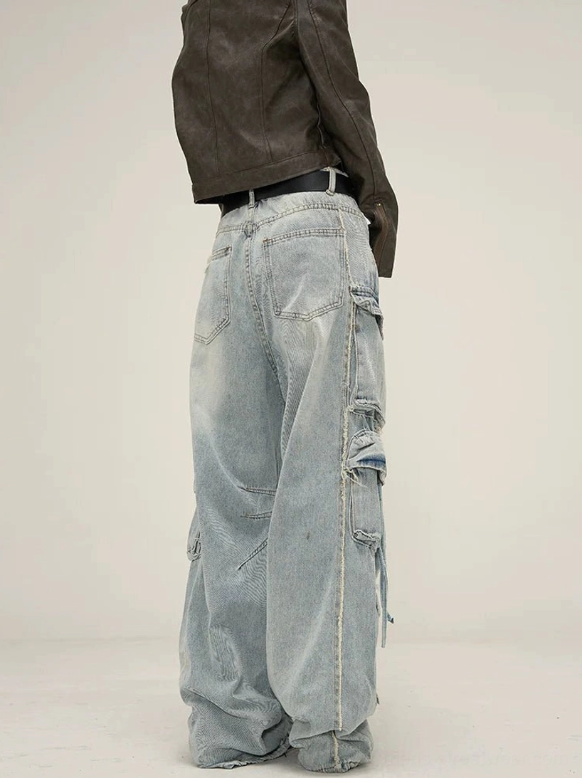 Light wash wide-leg cargo jeans rear view showing classic back pockets, loose denim leg shape, side drawstring detail, and raw frayed hems