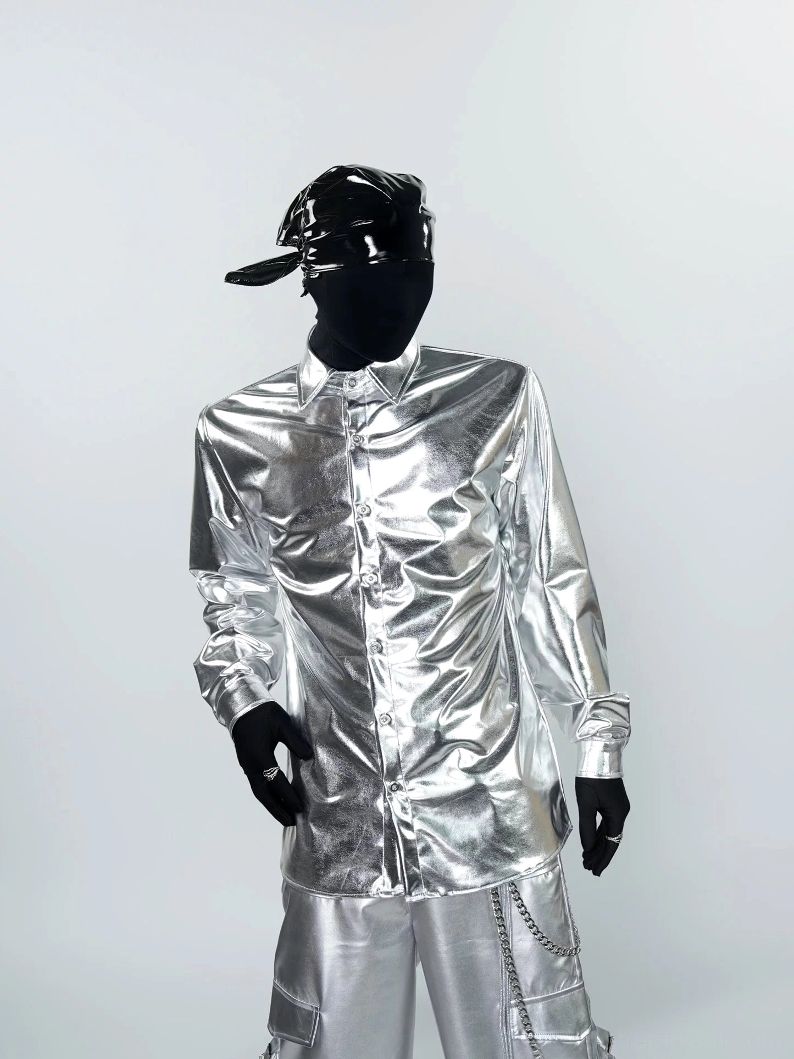 Front full-body view of a model wearing a shiny liquid metal silver long sleeve shirt with metallic cargo pants in a futuristic streetwear outfit