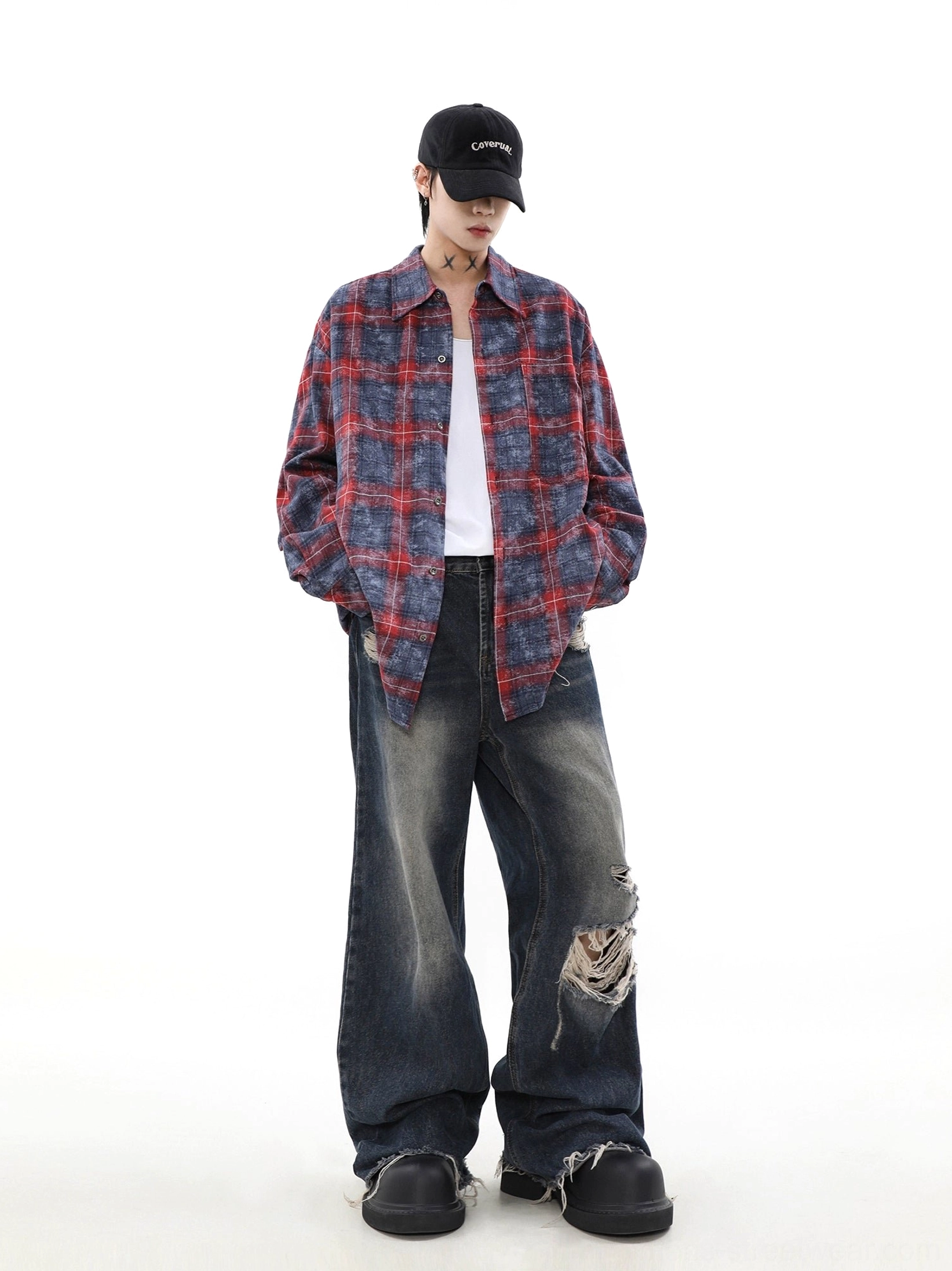 Close front view of a longline washed plaid overshirt with loose fit, white inner top, and ripped denim streetwear styling