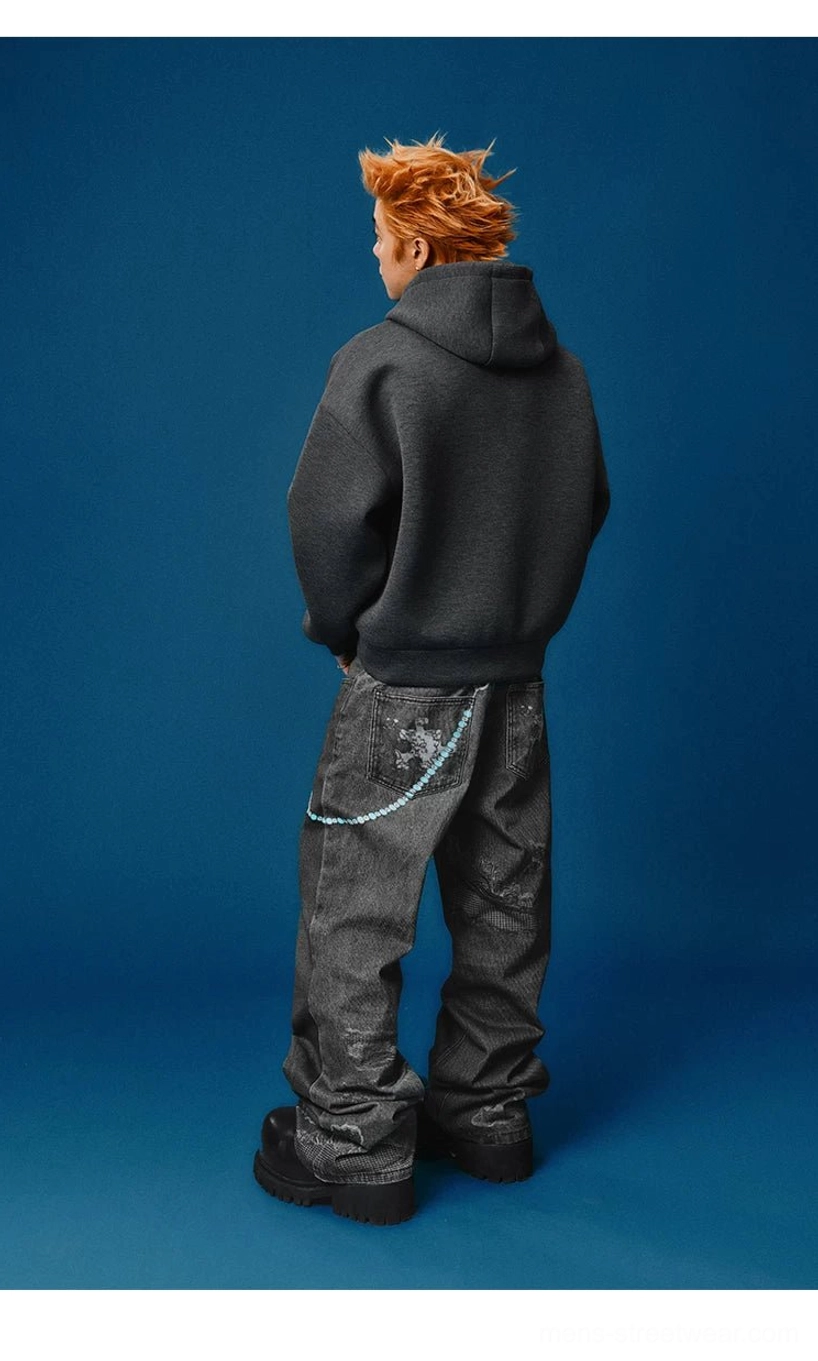 Back silhouette of loose black wide-leg distressed jeans styled with a dark gray hoodie and chunky black platform shoes